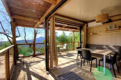 a house with a balcony with a table and chairs at CHALET U Castagnu in Venaco