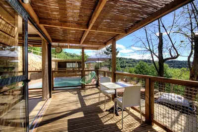 a patio with a table and chairs on a deck at CHALET U Castagnu in Venaco