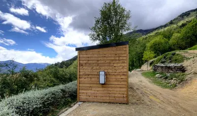 a wooden outbuilding with a door on a dirt road at CHALET U Castagnu in Venaco