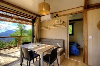 a dining room with a table and chairs and a balcony at CHALET U Castagnu in Venaco