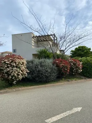 a building with flowers on the side of a street at Appartement T3 bord de mer résidence Aqualinda E55 in Poggio-Mezzana