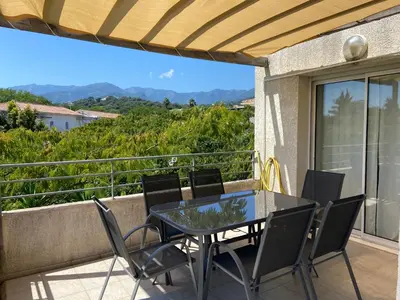 a patio with a table and chairs on a balcony at Appartement T3 bord de mer résidence Aqualinda E55 in Poggio-Mezzana
