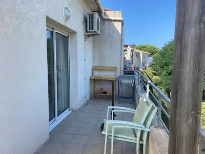 a balcony with two chairs sitting on the side of a building at Appartement T3 bord de mer résidence Aqualinda E55 in Poggio-Mezzana