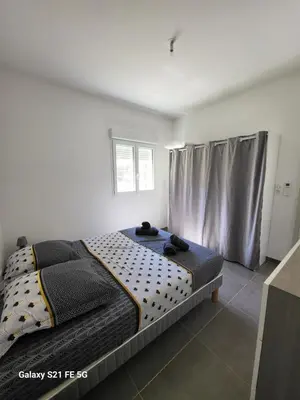 a bedroom with a bed and a window with curtains at T2 bord de mer in Albitreccia