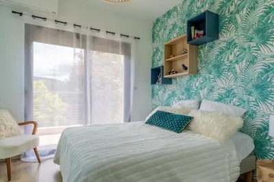 a bedroom with a large bed with a blue wall at Maison O Ciucciarella - Climatisée avec jacuzzi in Grosseto-Prugna