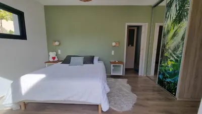 a bedroom with a white bed and a green wall at Maison O Ciucciarella - Climatisée avec jacuzzi in Grosseto-Prugna