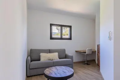 a living room with a couch and a table at Maison O Ciucciarella - Climatisée avec jacuzzi in Grosseto-Prugna