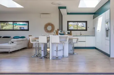 a kitchen and living room with a table and stools at Maison O Ciucciarella - Climatisée avec jacuzzi in Grosseto-Prugna