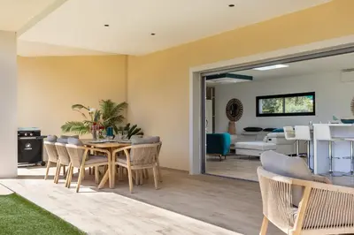 a dining room and living room with a table and chairs at Maison O Ciucciarella - Climatisée avec jacuzzi in Grosseto-Prugna