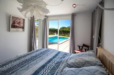 a bedroom with a bed and a swimming pool at Villa bord de mer avec piscine 200 métres plage in Zonza