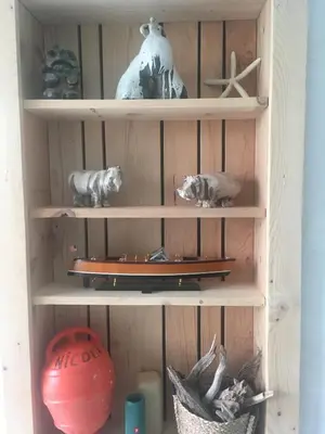 a wooden shelf with a boat and other items on it at Villa bord de mer avec piscine 200 métres plage in Zonza