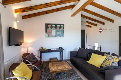 a living room with a couch and a tv at Villa bord de mer avec piscine 200 métres plage in Zonza