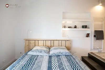 a bedroom with a bed with a blue and white blanket at Villa bord de mer avec piscine 200 métres plage in Zonza