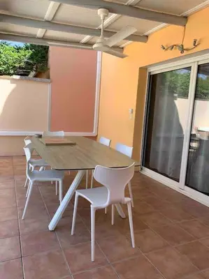 a dining room table and chairs on a patio at Villa VESTA 62m2 à St Cyprien 700 m de la plage et du village in Lecci