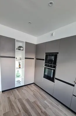 a kitchen with white walls and wooden floors at Proche porticcio, Coup de cœur asuré,Appartement de standing, rez de villa 6 couchages, climatisé à 150m de la plage, terrains de tennis in Grosseto-Prugna