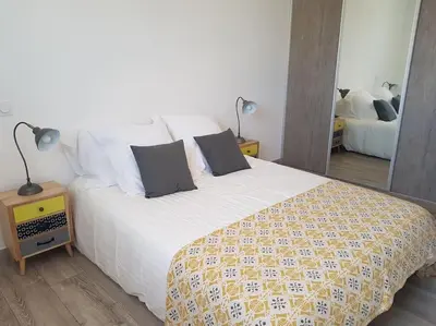 a bedroom with a large white bed with two pillows at Maison T3, 50m de la mer, cadre reposant in Santa-Lucia-di-Moriani