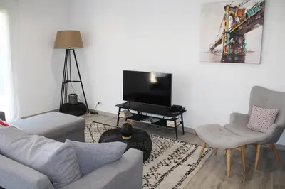 a living room with a couch and a flat screen tv at Maison T3, 50m de la mer, cadre reposant in Santa-Lucia-di-Moriani
