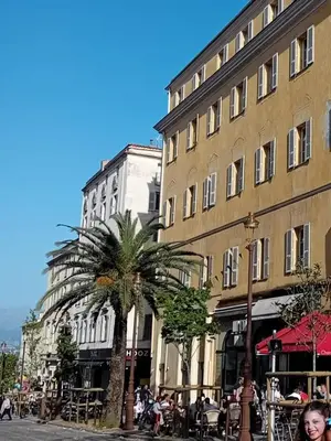 a woman is standing in front of a building at AJACCIO Beau Studio pour 3 a 4 pers en Plein Centre de la Vieille Ville Historique in Ajaccio