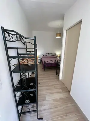 a room with a shelf with shoes and a bed at Hôtel les jardins de Sta Giulia avec piscine in Porto-Vecchio
