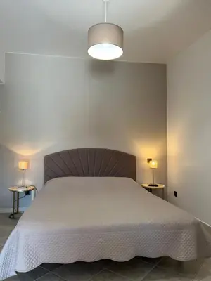 a bedroom with a bed and two tables with lamps at Hôtel les jardins de Sta Giulia avec piscine in Porto-Vecchio