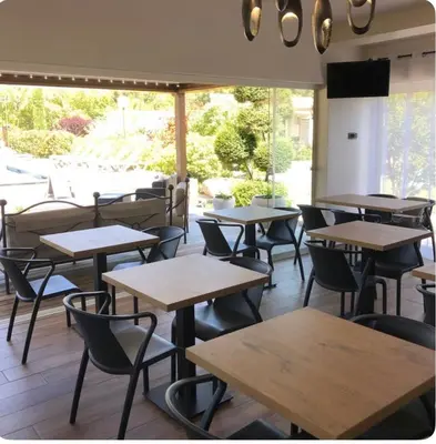 a row of tables and chairs in a restaurant at Hôtel les jardins de Sta Giulia avec piscine in Porto-Vecchio