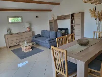 a living room with a table and a blue couch at Maison jumelée clôturée in Linguizzetta