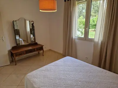 a bedroom with a mirror on a dresser next to a window at Maison jumelée clôturée in Linguizzetta