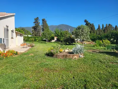 a garden with flowers in a yard with a house at Maison jumelée clôturée in Linguizzetta