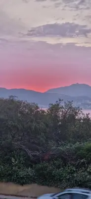 a sunset with trees and mountains in the background at Magnifique! Idéal! in Grosseto-Prugna