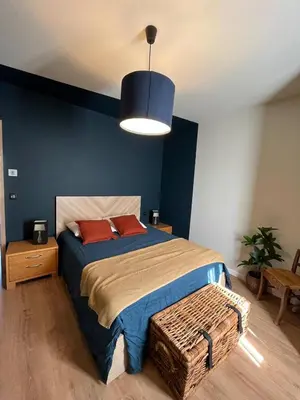 a bedroom with a large bed with a blue wall at Magnifique! Idéal! in Grosseto-Prugna