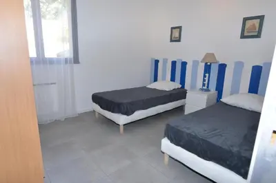a bedroom with two beds and a window at Corsicadream Barbicaja, superbe appartement dans villa, vue panoramique mer, piscine, proche Porticcio in Pietrosella