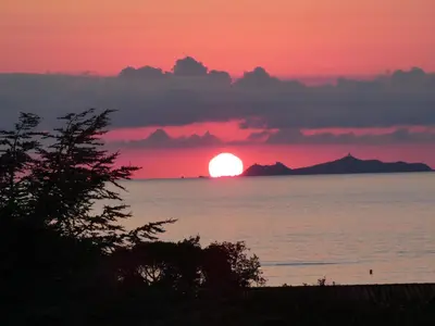 a sunset over the ocean with the sun in the sky at Corsicadream Barbicaja, superbe appartement dans villa, vue panoramique mer, piscine, proche Porticcio in Pietrosella