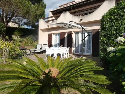 a house with a table and chairs on a patio at Corsicadream Barbicaja, superbe appartement dans villa, vue panoramique mer, piscine, proche Porticcio in Pietrosella