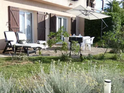 a patio with a table and chairs and an umbrella at Corsicadream Barbicaja, superbe appartement dans villa, vue panoramique mer, piscine, proche Porticcio in Pietrosella