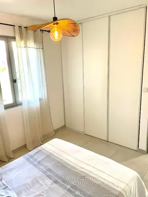 a bedroom with a bed and a ceiling fan at Mini maison entre mer et montagne in Aléria