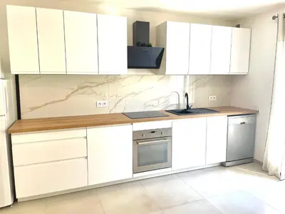 a kitchen with white cabinets and a sink at Mini maison entre mer et montagne in Aléria