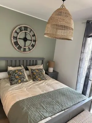a bedroom with a large clock on the wall at Duplex avec piscine, près de la mer, Cala Rossa in Lecci