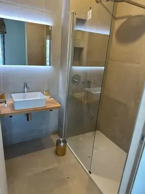 a bathroom with a glass shower and a sink at Duplex avec piscine, près de la mer, Cala Rossa in Lecci