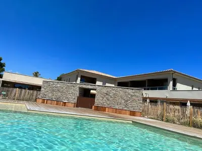 a house with a swimming pool in front of a house at Duplex avec piscine, près de la mer, Cala Rossa in Lecci