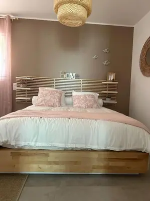 a bedroom with a large bed with pink pillows at Duplex avec piscine, près de la mer, Cala Rossa in Lecci