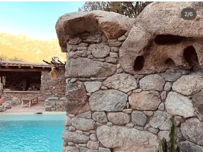 a stone wall next to a swimming pool at La Casa D'Ange Bergerie 5 étoiles de Luxe Piscine chauffée in Lama