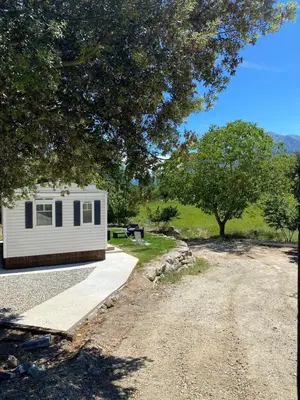 a small white trailer parked next to a dirt road at Mobil Home in Tralonca