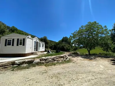 a mobile home on a dirt road next to a tree at Mobil Home in Tralonca