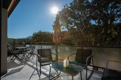a patio with chairs and a table and an umbrella at Casa Emma in Sollacaro