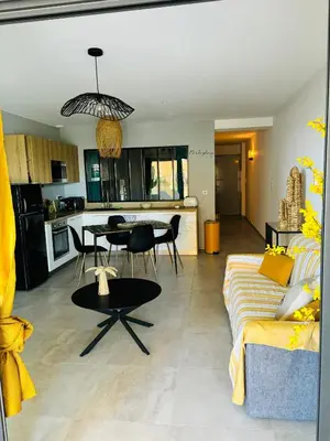 a living room with a couch and a table at Appartement moderne à Ajaccio de 45 m² avec terrasse vue mer in Ajaccio