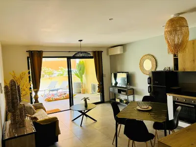 a living room with a table and a couch at Appartement moderne à Ajaccio de 45 m² avec terrasse vue mer in Ajaccio