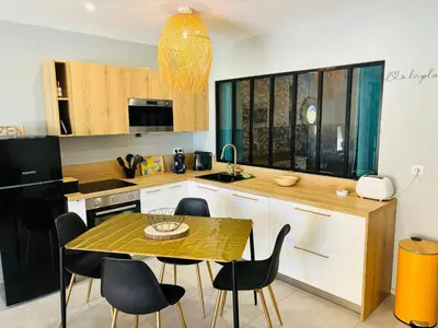 a kitchen with a table and chairs in a kitchen at Appartement moderne à Ajaccio de 45 m² avec terrasse vue mer in Ajaccio
