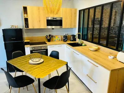 a kitchen with a table and chairs and a sink at Appartement moderne à Ajaccio de 45 m² avec terrasse vue mer in Ajaccio