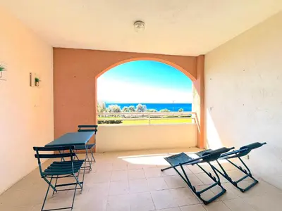 a room with two tables and chairs and a window at Studio Cosy à 50m de la plage avec Parking - Résidence ARIA MARINA route des sanguinaires in Ajaccio