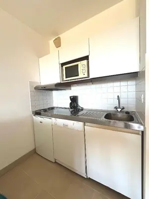 a kitchen with a sink and a microwave at Studio Cosy à 50m de la plage avec Parking - Résidence ARIA MARINA route des sanguinaires in Ajaccio